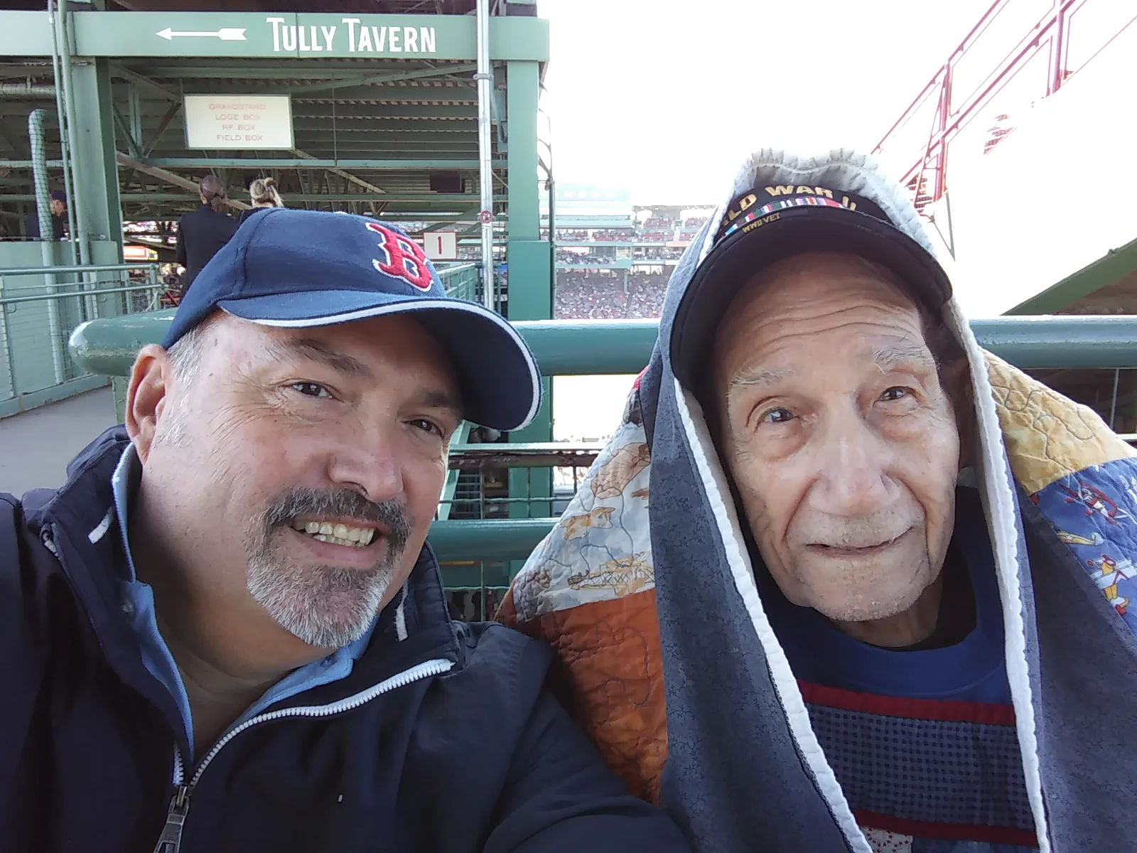 Don Giguere smiling with a veteran in stadium seating at a Red Sox game